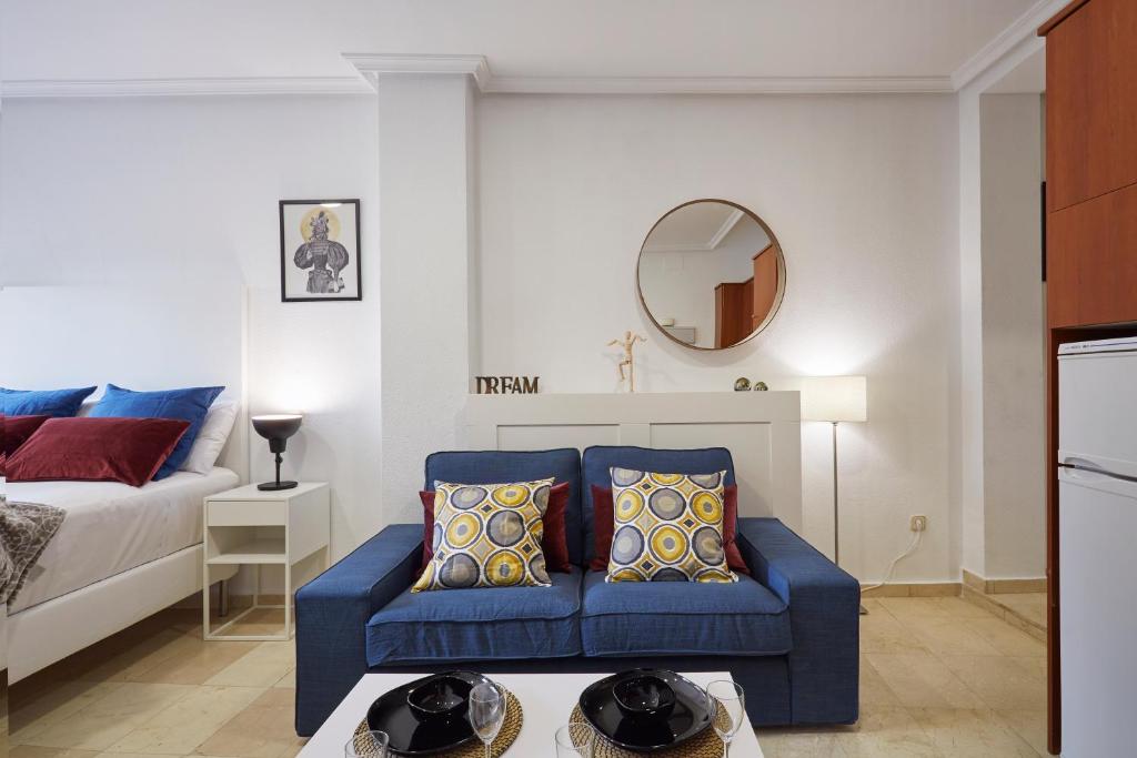 sala de estar con sofá azul y cama en LEEWAYS APARTMENT XXII in GRAN VÍA, en Madrid