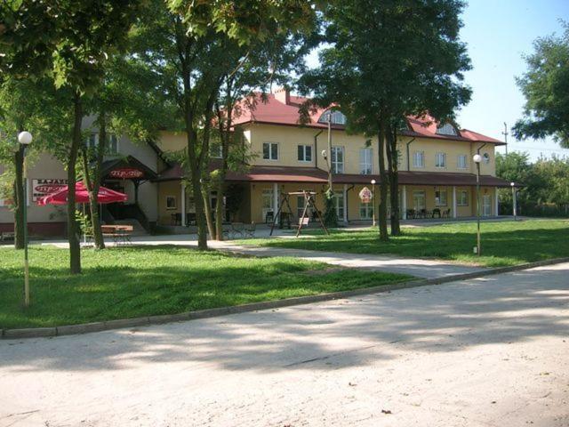 a large building with trees in front of a street at Zajazd Tip Top in Iganie