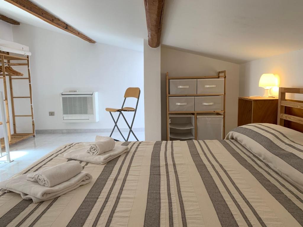 um quarto com uma cama com toalhas em Gioberti 25 em Alghero