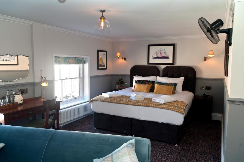 1 dormitorio con 1 cama grande y 1 sofá azul en Admiral Hardy, en Londres