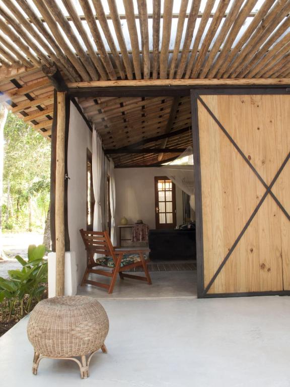 a wooden door leading into a living room with a chair at The Lion Cottage- Charming Studios in Santo André