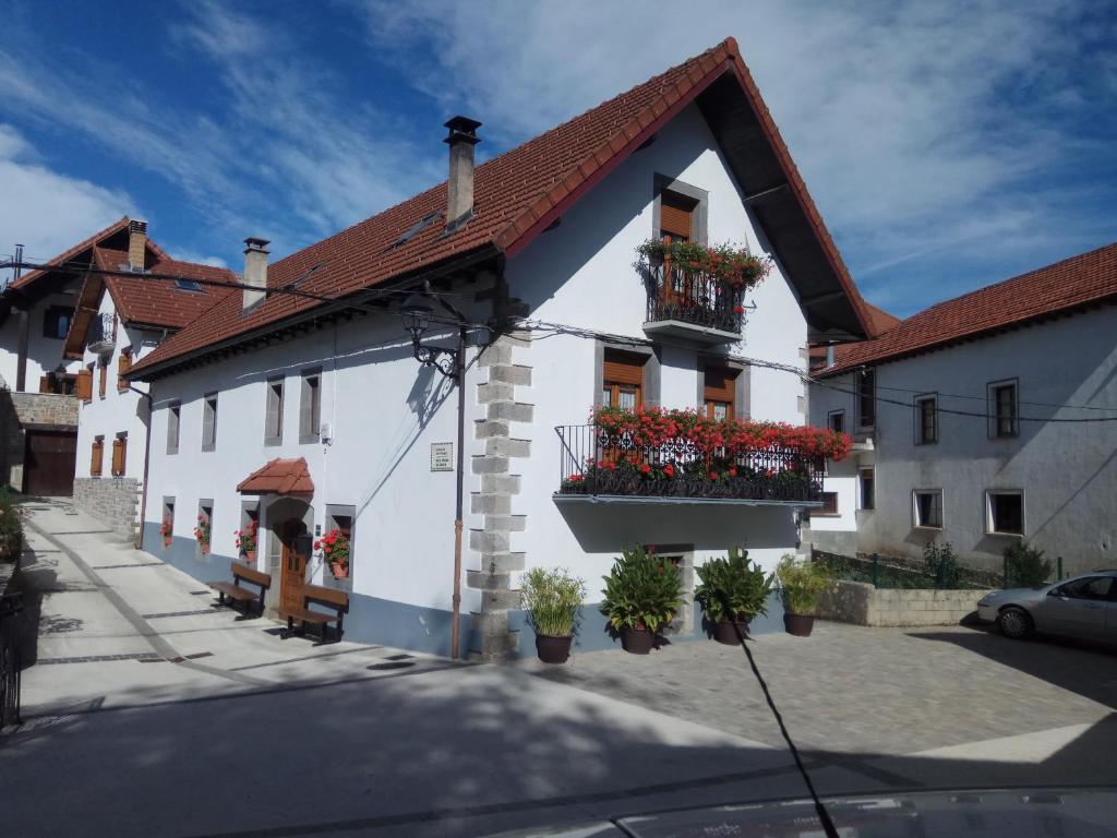 um edifício branco com caixas de flores nas janelas em Casa Ayabe em Jaurrieta