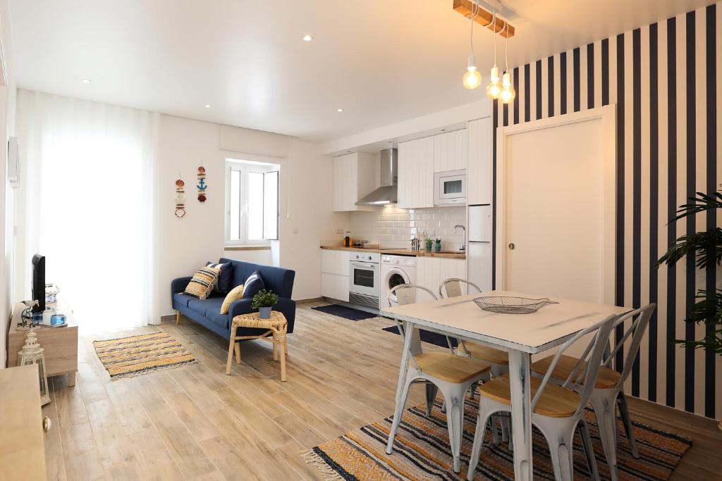 een woonkamer met een tafel en een blauwe bank bij Sea & Sun Apartment II in Nazaré