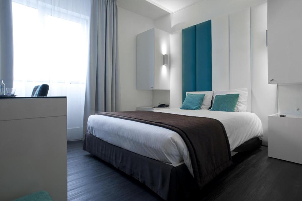 a bedroom with a large bed and a large window at Hotel Ecu in Genk