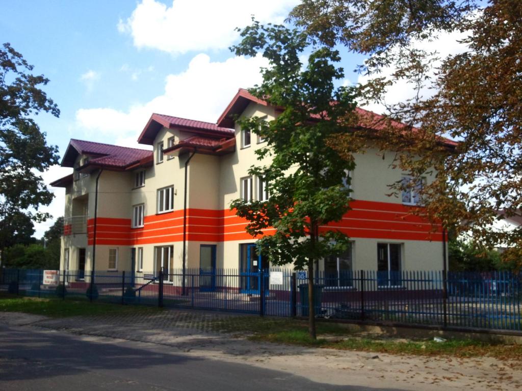 a building with an orange and white stripe on it at Noclegi Pod Kasztanami in Marki