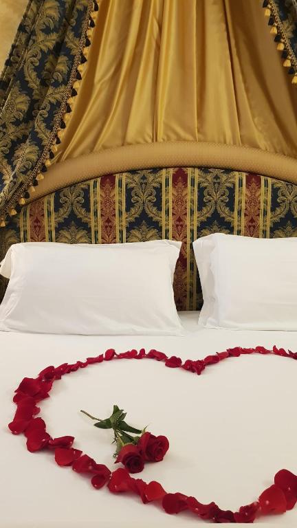 un lit avec un bouquet de roses sur le lit dans l'établissement Ca' Bragadin e Carabba, à Venise