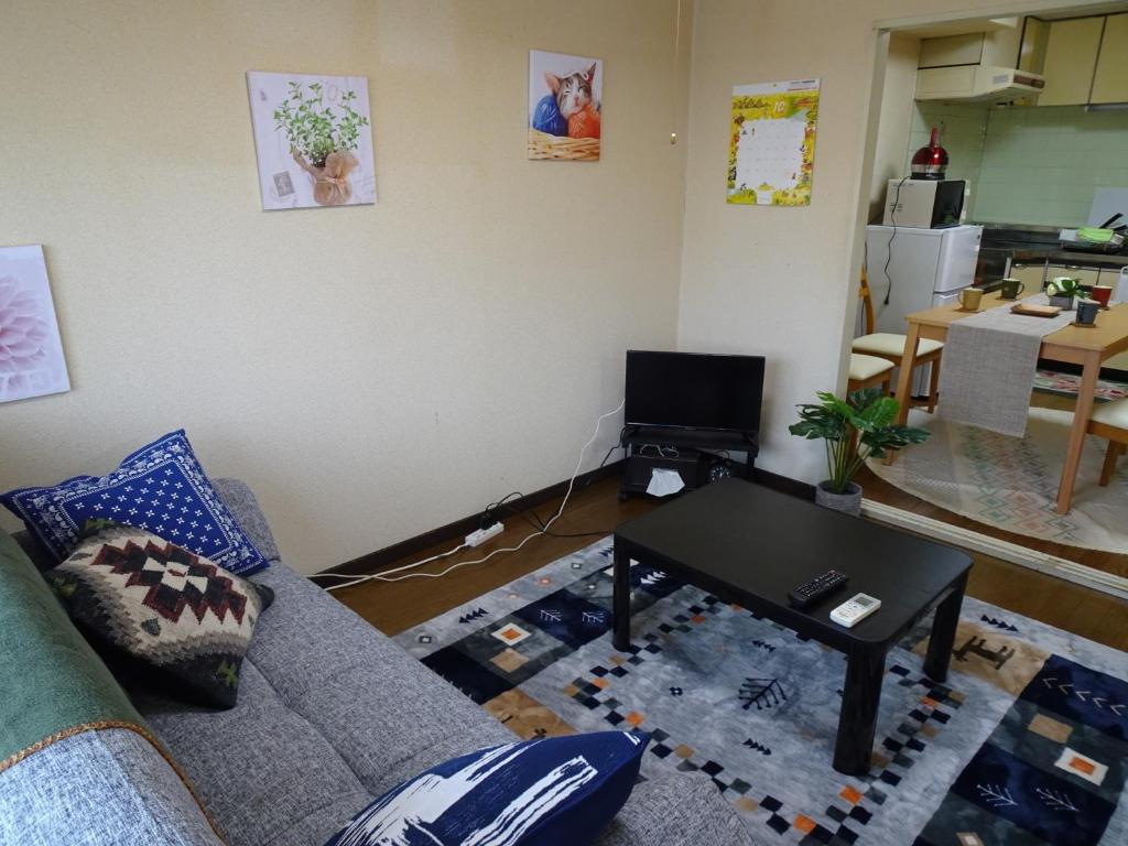 uma sala de estar com um sofá e uma mesa em Merbeil Otsuka / Vacation STAY 4984 em Nikaidō