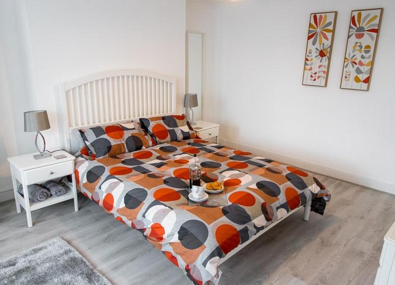 a bedroom with a large bed with a colorful comforter at Sandy bottoms in Llandudno