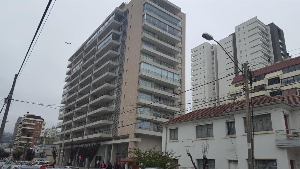 un edificio de apartamentos alto en una ciudad con edificios en Delpino Propiedades Costa Viña, en Viña del Mar