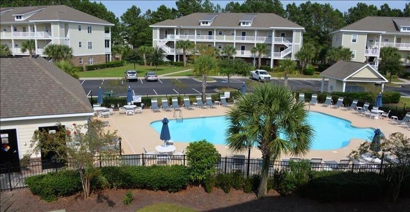 a large swimming pool in a resort with a parking lot at 1515 Willow Bend Condo in North Myrtle Beach