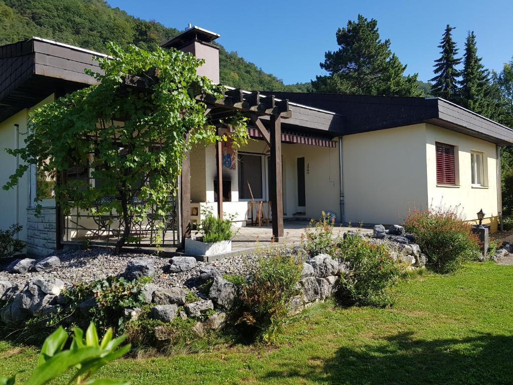 een huis met een stenen muur ervoor bij Gästehaus Luma in Egerkingen