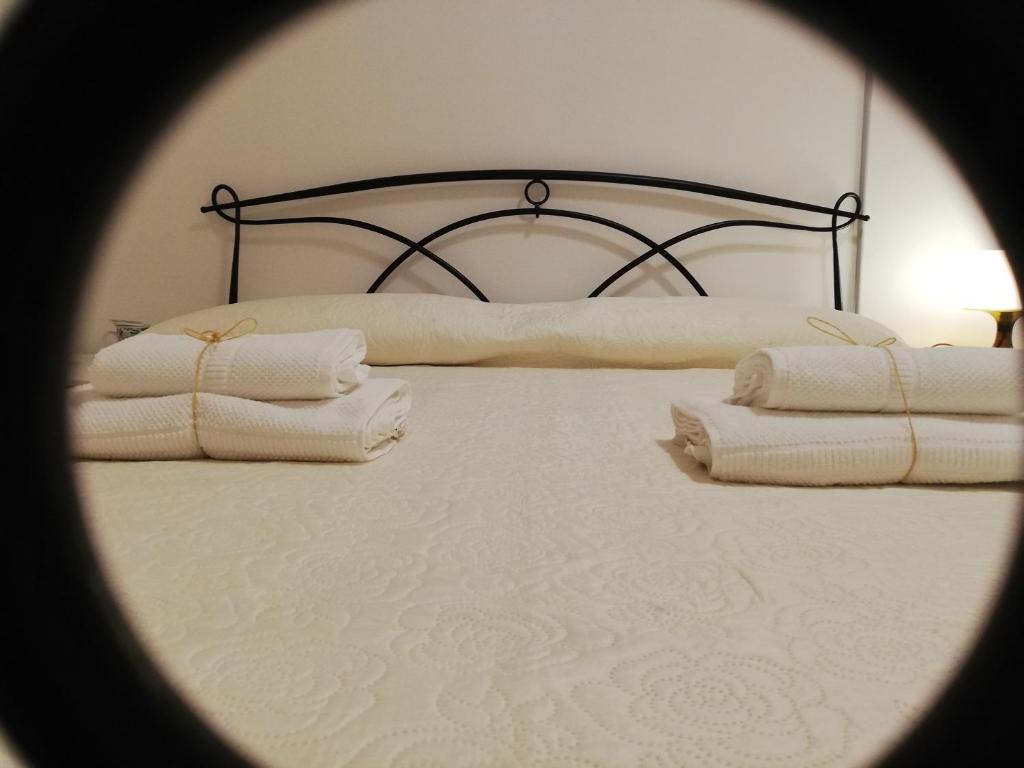 un letto chiuso con asciugamani di Santa Maria in Platea - Apartment a Montescaglioso