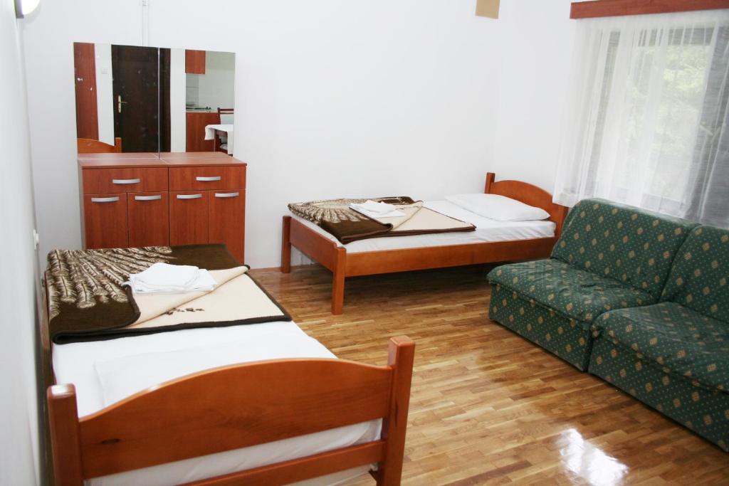 sala de estar con 2 camas y sofá en Studios Šumska Kuća 1, en Kopaonik