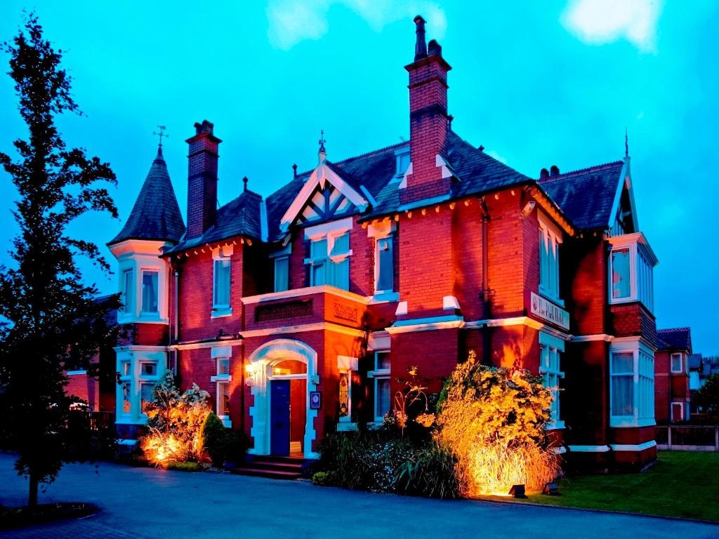 a large red brick house with lights on it at Trivelles Park Hotel in Preston