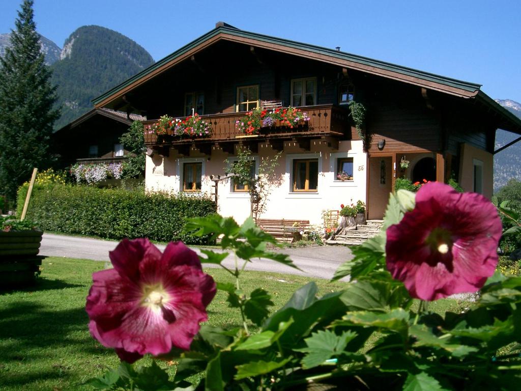 uma casa com flores cor-de-rosa em frente em Ferienwohnung Waldhäusl em Sankt Martin bei Lofer