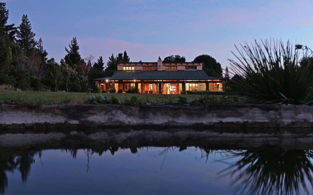 a house sitting on the side of a body of water at Trengwainton House in Hogsback