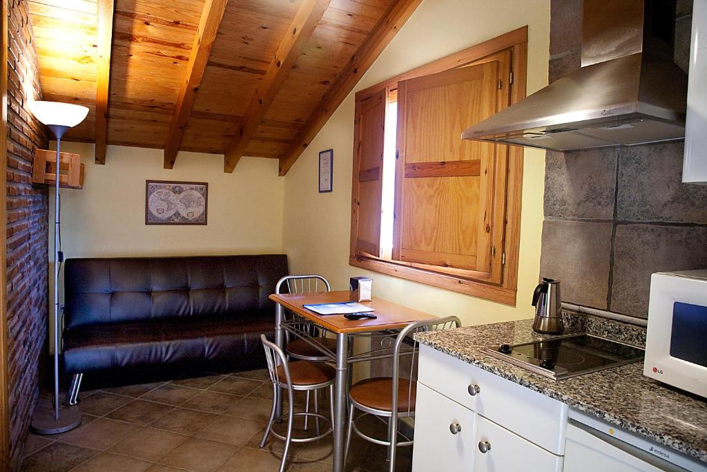 cocina con sofá y mesa con sillas en Apartamentos Cuevas del Mar en Nueva de Llanes