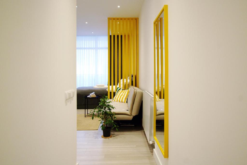 Banana Apartments في باتومي: غرفة معيشة مع مرآة وأريكة