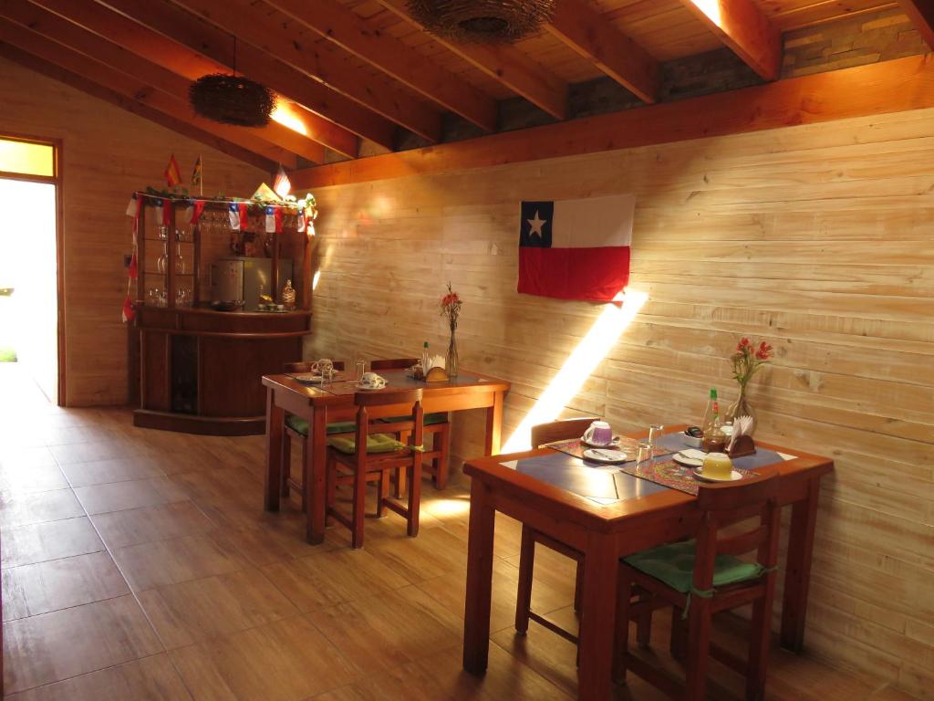 a dining room with two tables and a kitchen at Hostal Blanca Estela in Concón