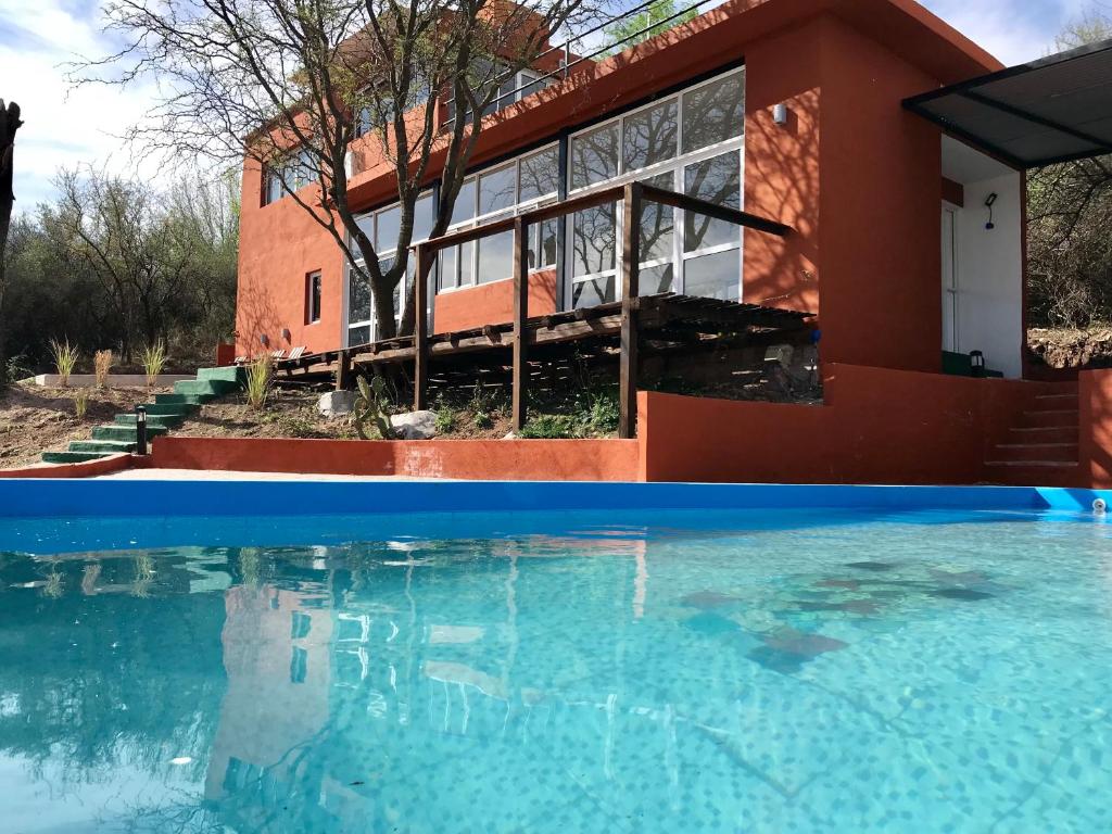 a house with a swimming pool in front of it at Alondra Boutique in Villa Cura Brochero