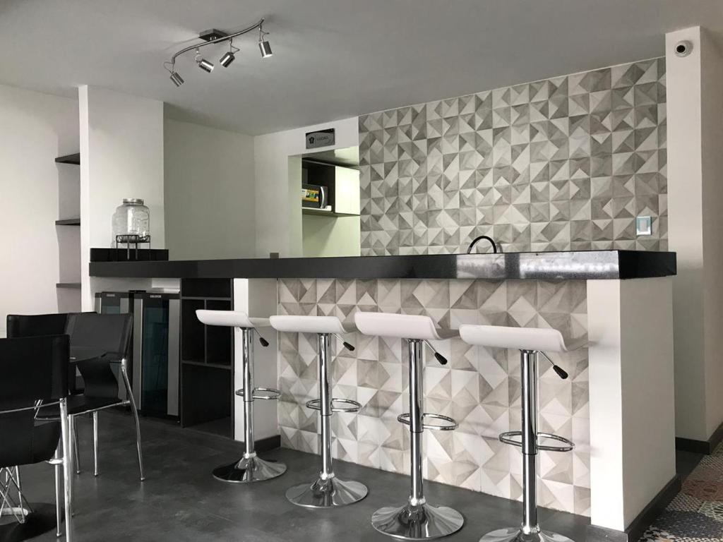 a kitchen with a counter with bar stools at HOTEL ZARCILLEJO in Pasto