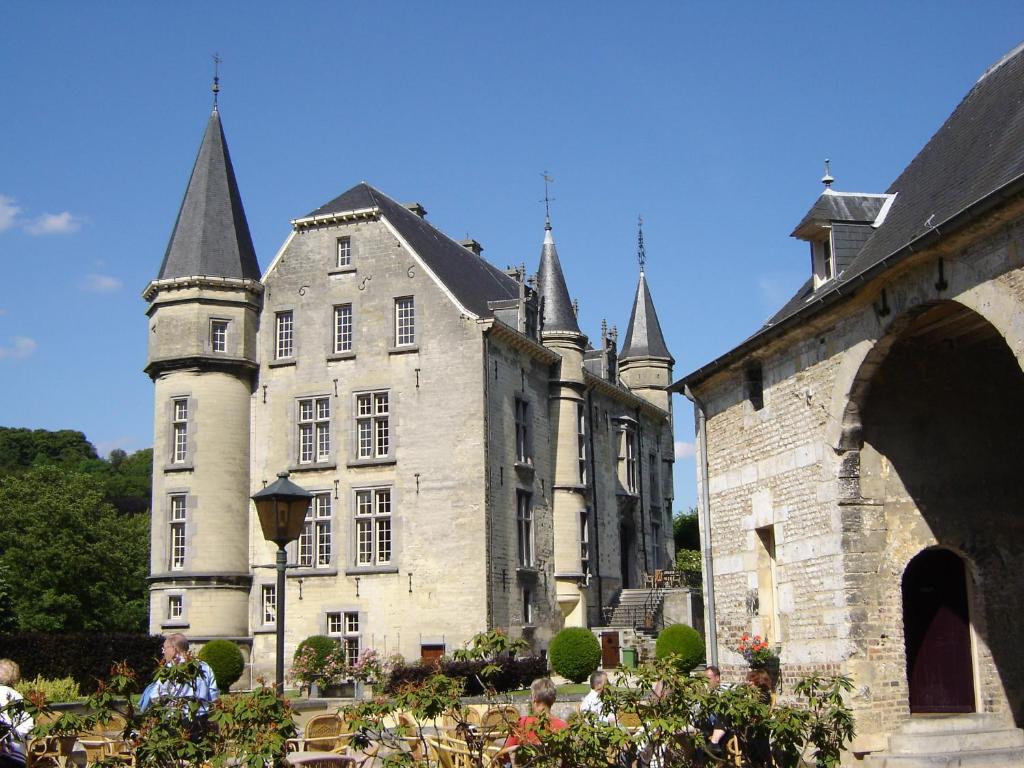 an old castle with a tower and a building at Kasteel Schaloen in Valkenburg