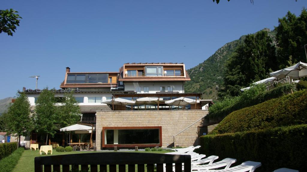 una casa en la cima de una colina con un patio en Hotel Milano Alpen Resort Meeting&Spa, en Castione della Presolana