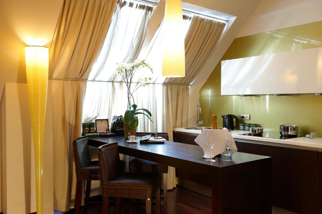 kuchnia ze stołem i krzesłami oraz oknem w obiekcie MyPlace Premium Apartments w Wiedniu