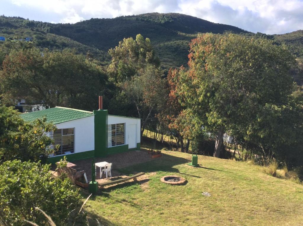 a small white house with a green roof at Casa rural tipo loft in Guatavita