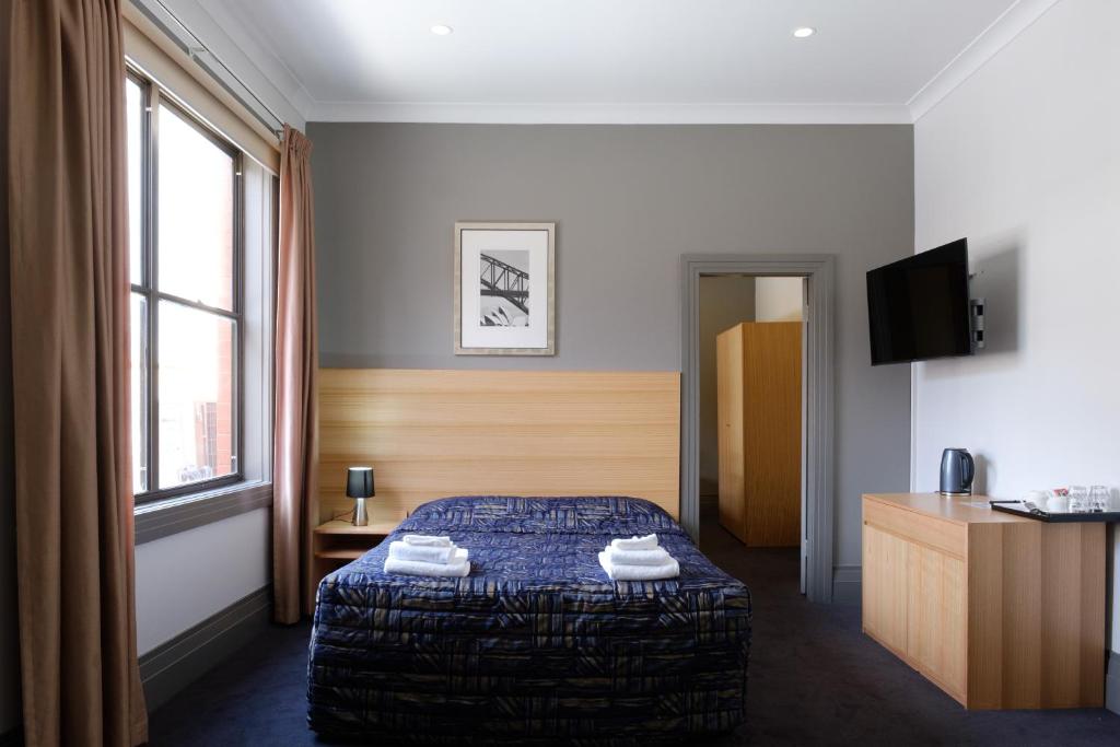a bedroom with a bed and a television at Royal Exhibition Hotel in Sydney