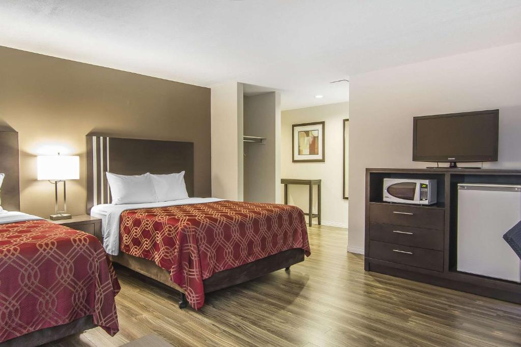 a hotel room with a bed and a tv at Econo Lodge Inn and Suites Lethbridge in Lethbridge