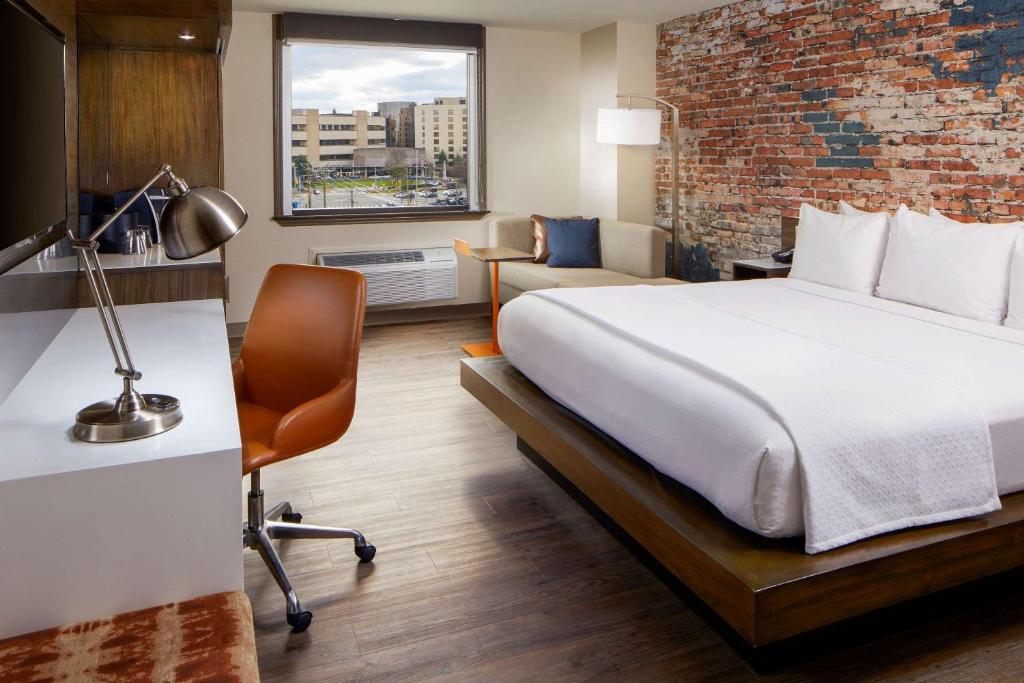 a hotel room with a bed and a brick wall at The Lodge at Duke Medical Center in Durham