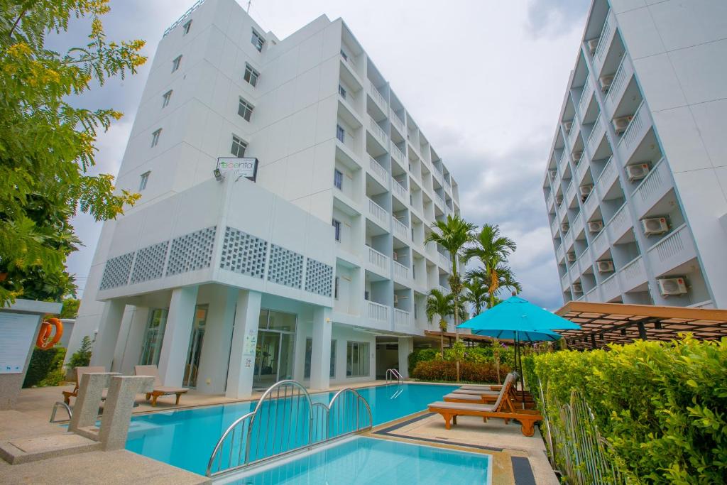 ein Hotel mit einem Pool und einem Gebäude in der Unterkunft Recenta Suite Phuket Suanluang in Phuket