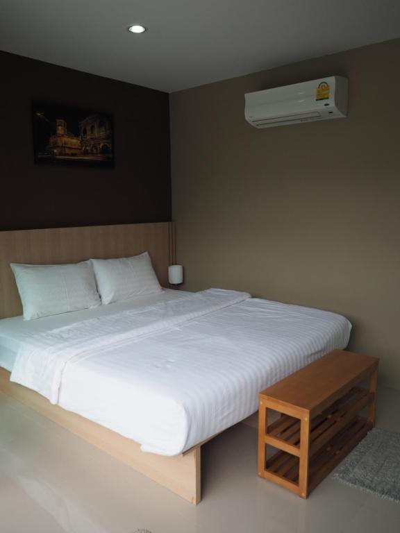 a bedroom with a large white bed and a air conditioner at Sleepwell@naiyang in Nai Yang Beach