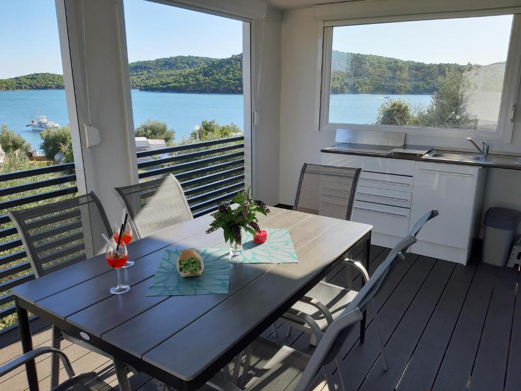 a dining room table with a view of the water at Mobile Home Tina Tisno in Tisno