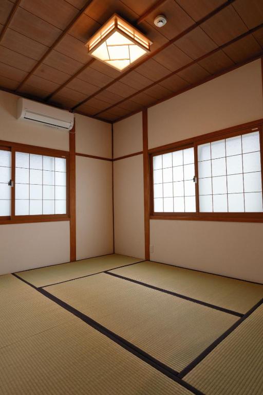 an empty room with a large room with windows at Guesthouse Iwase in Toyama