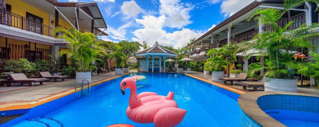 una piscina en un complejo con flamencos rosas. en Vdara Pool Resort Spa Chiang Mai en Chiang Mai
