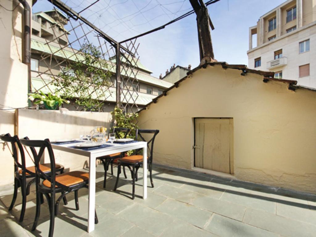 patio ze stołem i krzesłami w budynku w obiekcie Mercalli 1 w Mediolanie