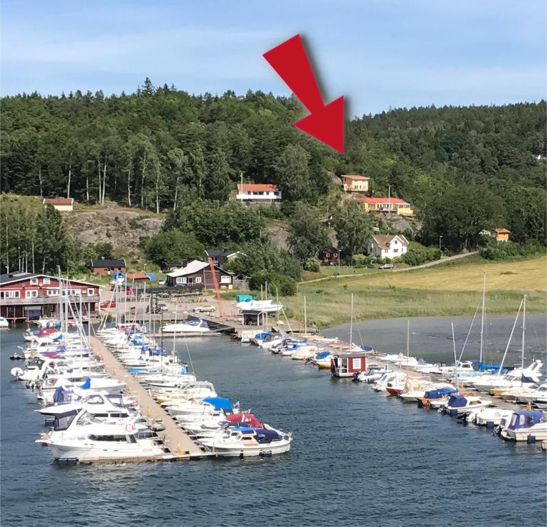 een groep boten aangemeerd op een dok met een rode pijl bij Riddarhuset in Ljungskile