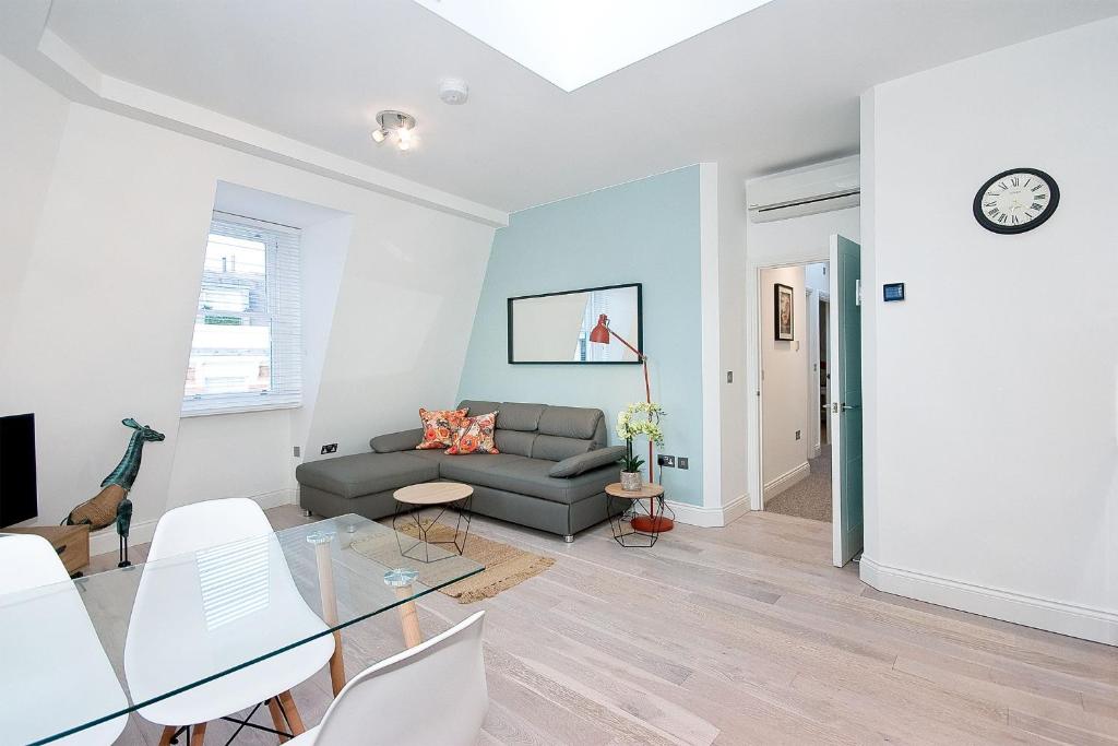 - un salon avec un canapé et une table dans l'établissement Interlude House E Penthouse by City Living London, à Londres