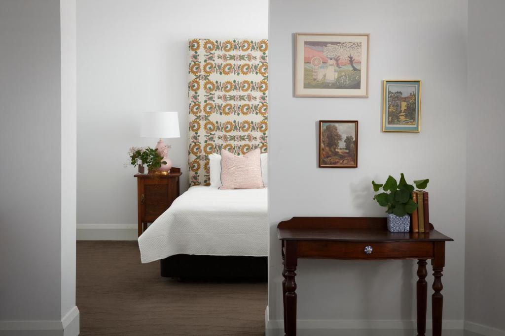 sypialnia z łóżkiem i stołem z rośliną w obiekcie The Provincial Boutique Hotel w mieście Ballarat