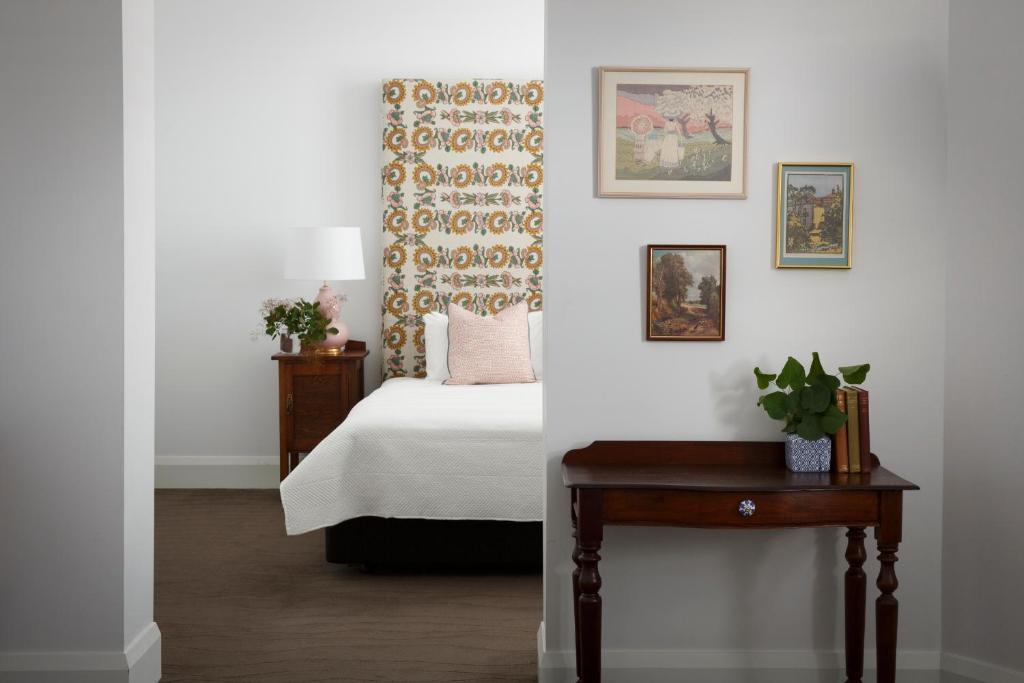 a bedroom with a bed and a table with a plant at The Provincial Boutique Hotel in Ballarat