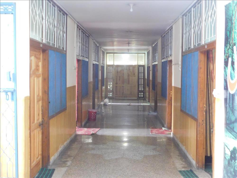pusty korytarz w budynku z drewnianymi drzwiami w obiekcie Lalazar hotel w mieście Abbottabad