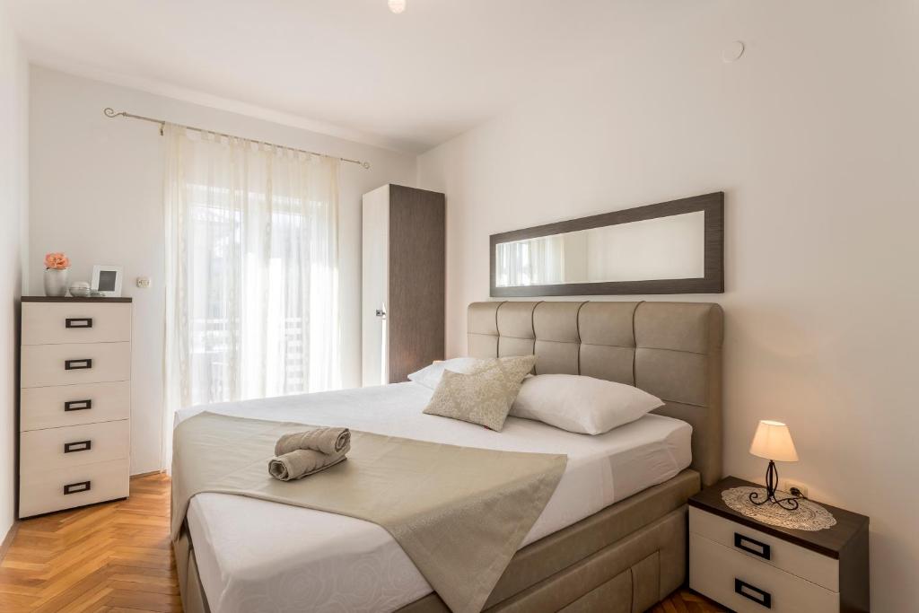 a bedroom with a large bed with a headboard at Luxury apartment Karla in Split