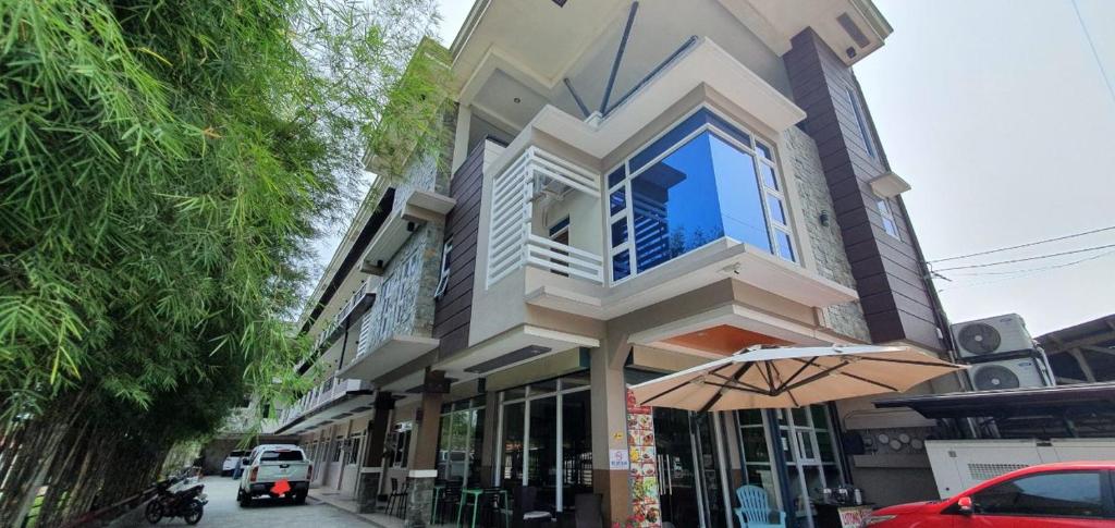 a building with an umbrella in front of a street at Felicidad Resto and Pension House in General Santos