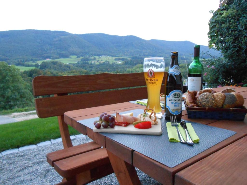 a table with a plate of food and two bottles of beer at Teisenbergblick in Gschwend