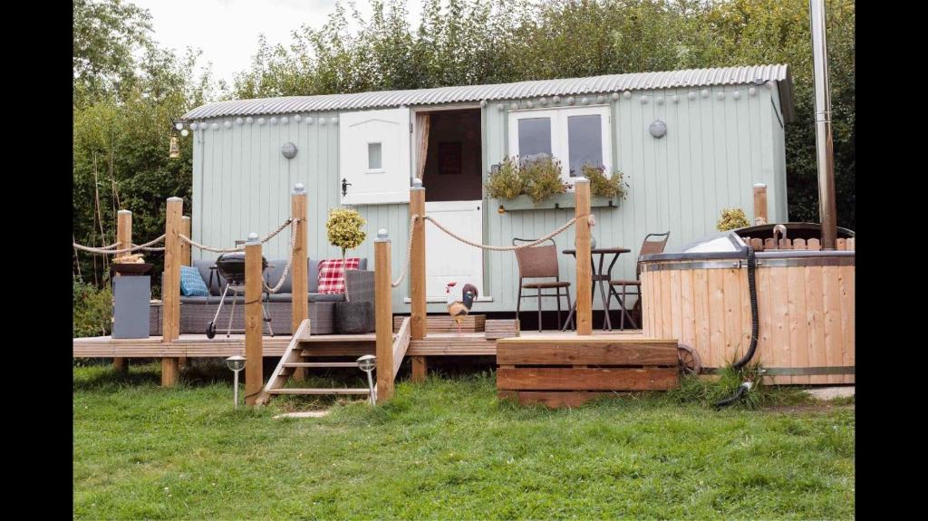 una casa pequeña con terraza y remolque en Shepherds Hut with Hot Tub en Lymington