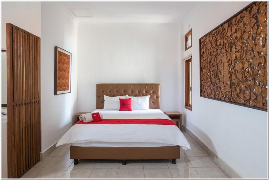 a bedroom with a large bed with red pillows at Koolkost near Padang Galak Beach in Denpasar