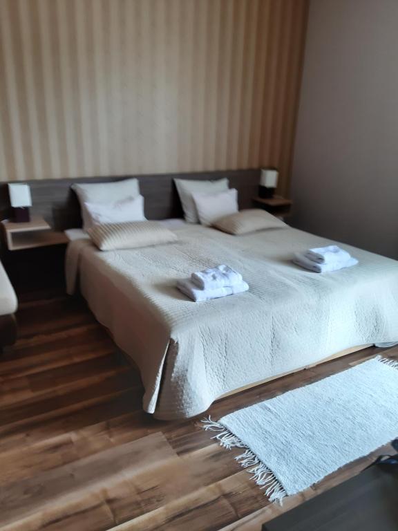 sypialnia z dużym łóżkiem z dwoma ręcznikami w obiekcie MELODY APARTMAN w Zalakaros