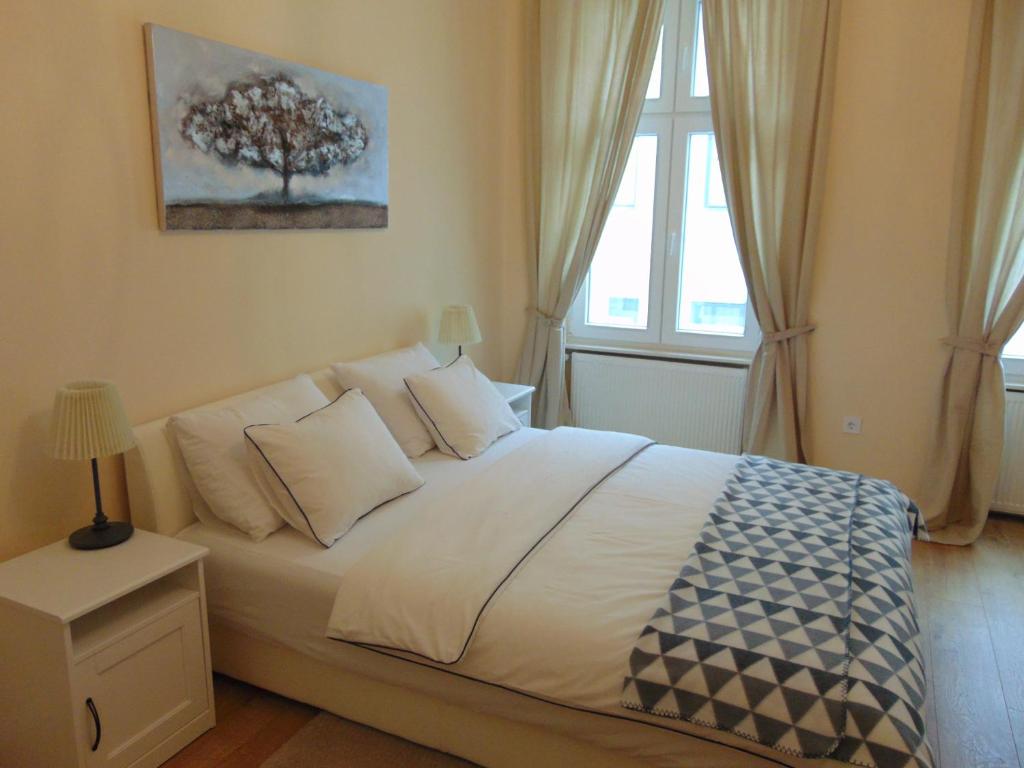 a bedroom with a bed with a tree on the wall at Apartments Radićeva in Zagreb